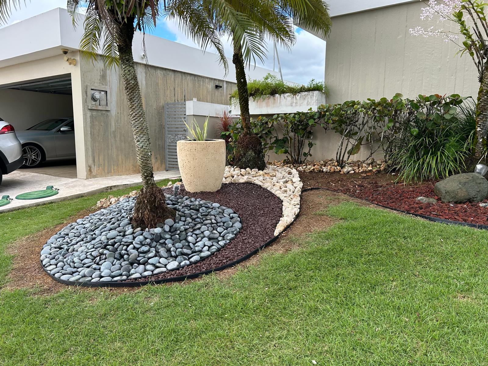 Diseño de jardín con piedra decorativa en entrada de residencia